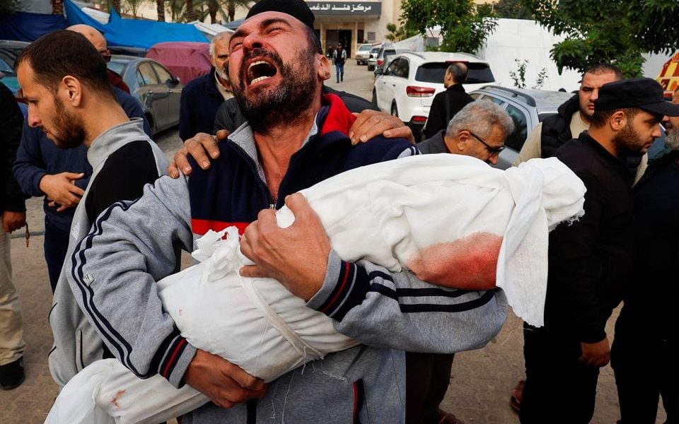 A Palestinian man reacts as he carries the body of his niece Hanan Kaloob, who was killed in an Israeli strike, at Nasser hospital in Khan Younis in the southern Gaza Strip November 22, 2023. REUTERS/Mohammed Salem/File Photo