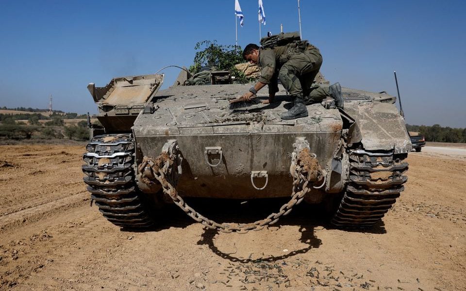 An Israeli soldier clears an armoured personnel carrier (APC), near Israel's border after leaving Gaza, during the temporary truce between the Palestinian Islamist group Hamas and Israel, in Israel, November 24, 2023. REUTERS/Amir Cohen