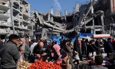 Palestinians shops in an open-air market near the ruins of houses and buildings destroyed in Israeli strikes during the conflict, amid a temporary truce between Hamas and Israel, in Nuseirat refugee camp in the central Gaza Strip November 30. REUTERS/Ibraheem Abu Mustafa
