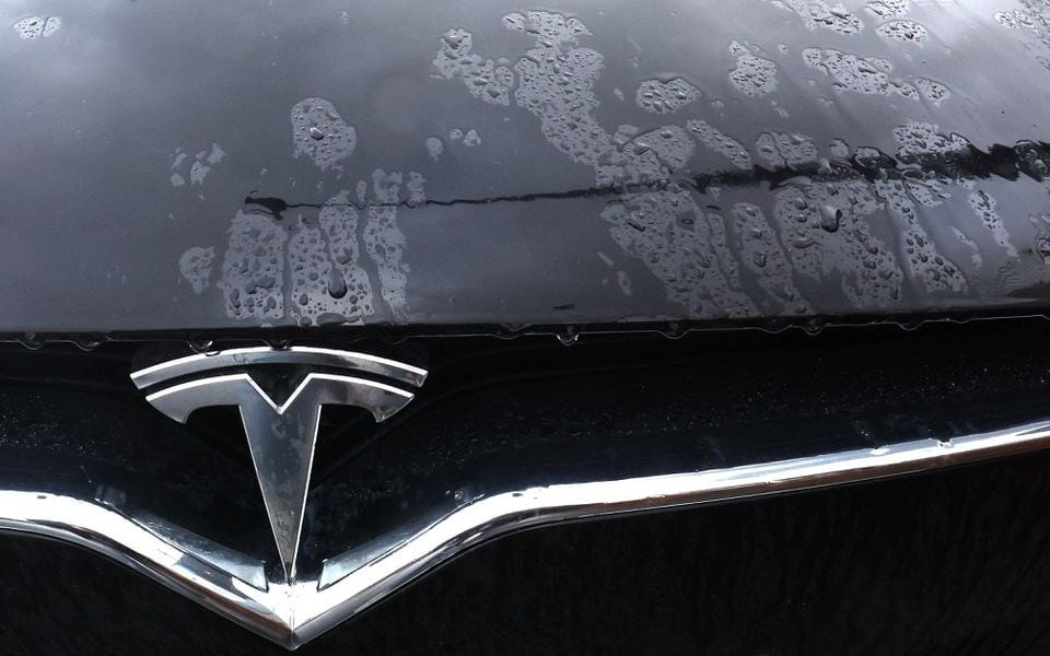 The logo of a Tesla electric vehicle is placed on a car seen outside a dealership in Drogenbos, Belgium November 25, 2023. REUTERS/Yves Herman/File Photo