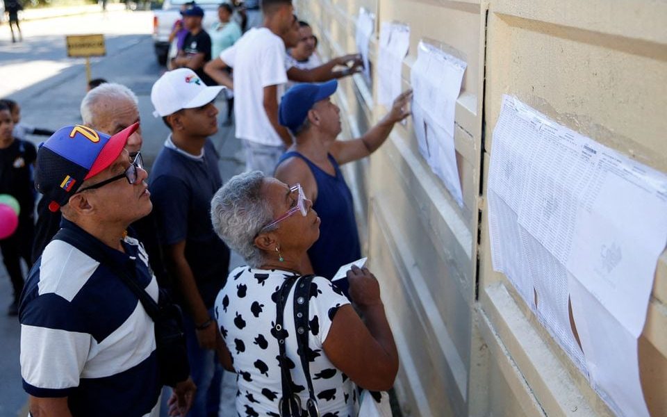 People look at the electoral list on the day of an electoral referendum over Venezuela's rights to the potentially oil-rich region of Esequiba, which has long been the subject of a border dispute between Venezuela and Guyana, in Caracas, Venezuela December 3, 2023. REUTERS/Leonardo Fernandez Viloria