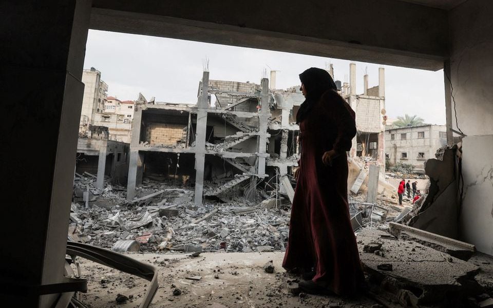 A Palestinian woman stands at the site of Israeli strikes on houses in Khan Younis, in the southern Gaza Strip December 14, 2023. REUTERS/Ibraheem Abu Mustafa