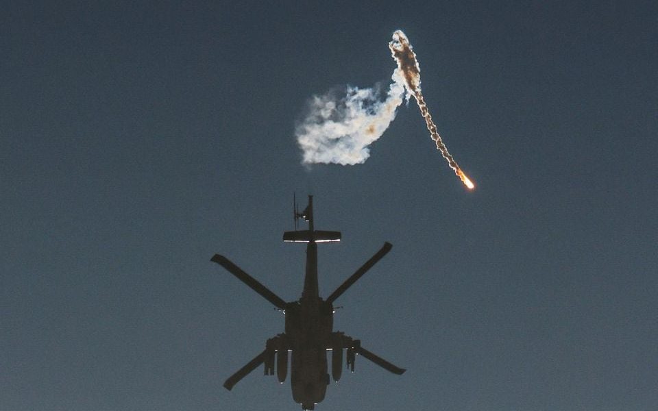 An Israeli military helicopter releases a flare over the Israel-Gaza border, after a temporary truce between Israel and the Palestinian Islamist group Hamas expired, as seen from southern Israel, December 1, 2023. REUTERS/Amir Cohen