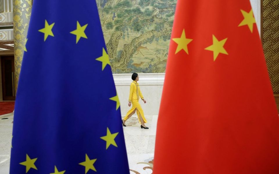 An attendant walks past EU and China flags ahead of the EU-China High-level Economic Dialogue at Diaoyutai State Guesthouse in Beijing, China June 25, 2018. REUTERS/Jason Lee/File photo