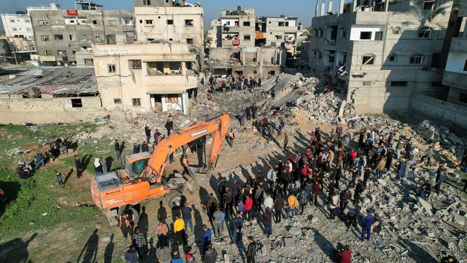 Palestinians gather at the site of an Israeli strike on a house, as the conflict between Israel and the Palestinian Islamist group Hamas continues, in Rafah in the southern Gaza Strip December 19, 2023. REUTERS/Shadi Tabatibi