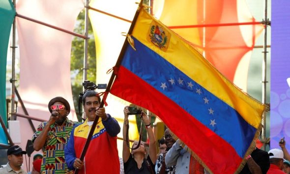 Venezuelan President Nicolas Maduro waves a Venezuelan flag, as he participates in the closing event for the campaign, ahead of the referendum over a potentially oil-rich territory, part of its long-running dispute with its neighbour Guyana, in Caracas, Venezuela, December 1, 2023. REUTERS/Leonardo Fernandez Viloria/File Photo