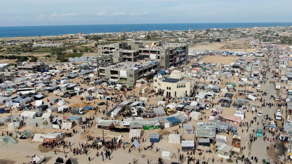People walk near tent camps where displaced Palestinians, who fled their houses due to Israeli strikes amid the ongoing conflict between Israel and the Palestinian Islamist group Hamas, take shelter in Rafah in the southern Gaza Strip, December 9, 2023. REUTERS/Mustafa Thraya/ FILE PHOTO